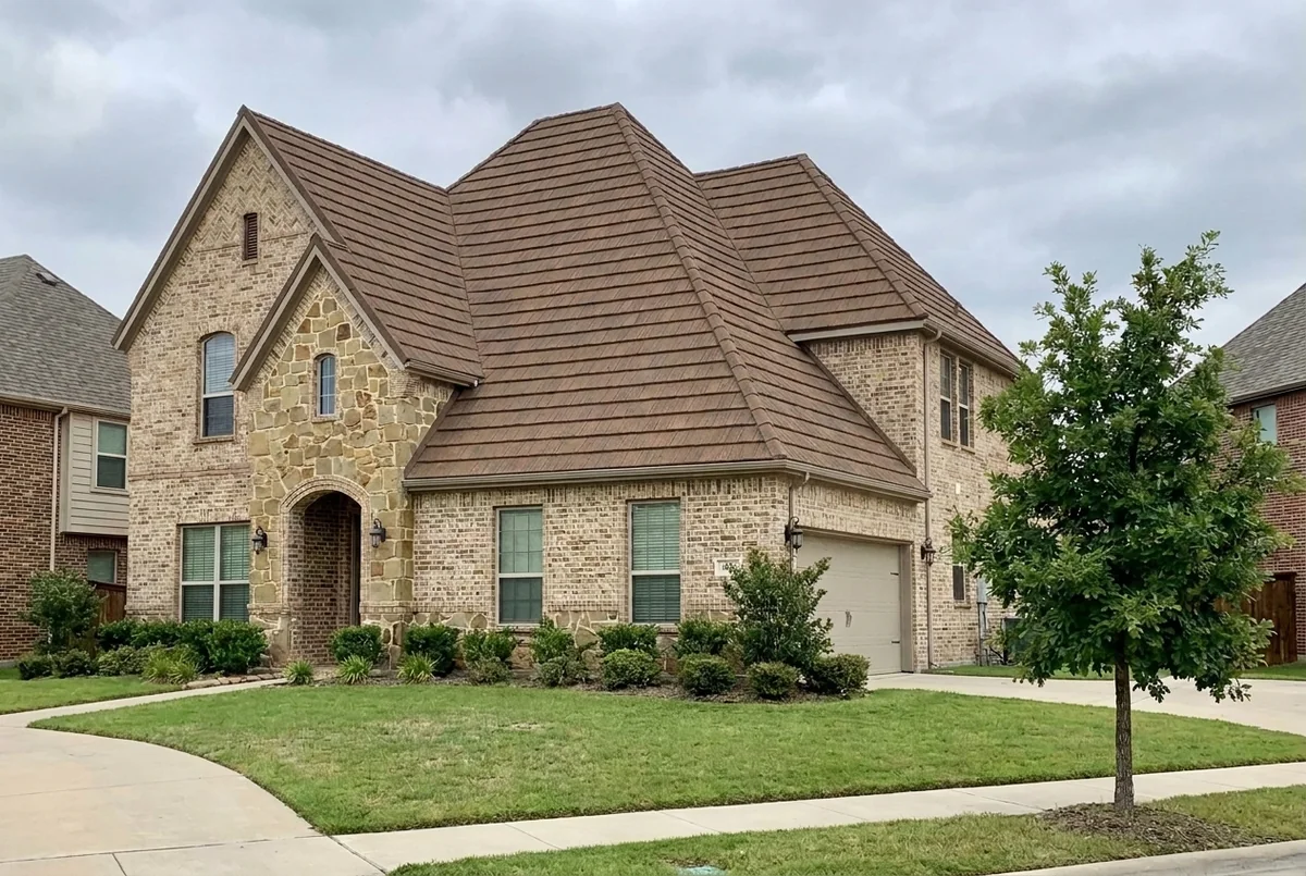 A sample two-story brick house, shown with its old roof and with a brown steel roof that looks like wood shake.